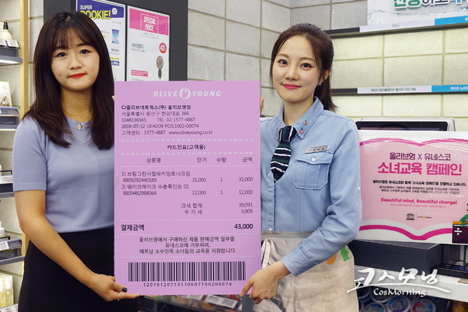 올리브영이 오는 18일까지 유네스코 소녀교육 캠페인 위크를 연다. 사진은 올리브영 고객과 직원이 핑크영수증을 들고 있는 모습.