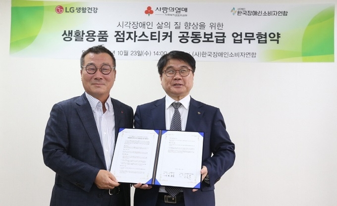 박헌영 LG생활건강 상무<사진 왼쪽>와 이병돈 한국장애인소비자연합 대표가 한국장애인소비자연합에서 '생활용품 점자스티커 공동보급'을 위한 업무협약을 맺고 기념 촬영에 임했다.