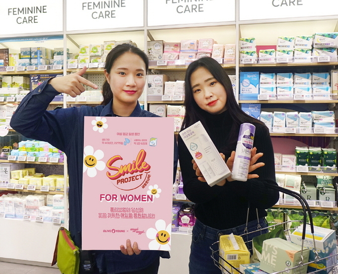 올리브영 명동 플래그십 매장에서 직원과 고객이 포 우먼 캠페인을 소개하고 있다.