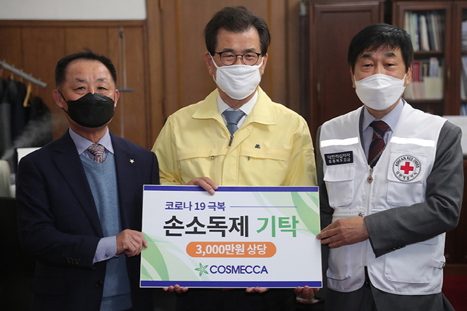 코스메카코리아가 코로나19 확산 방지와 피해 지원을 위해 손 소독제를 자체 생산해 충북도청을 포함한 주요 단체와 기관에 기부했다. 이시종 충북지사<사진 가운데>를 만나 손 소독제를 기부한 장면.