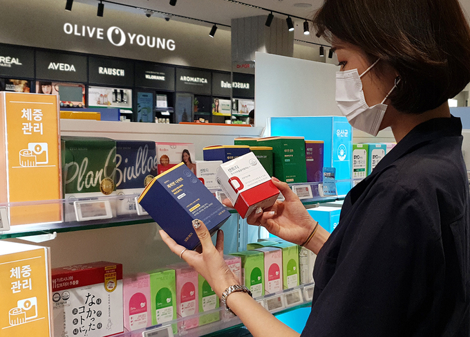 올리브영 명동 플래그십 매장을 방문한 고객이 슬리밍 제품을 살펴보고 있는 모습.
