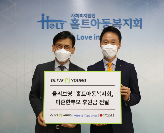 김호현 홀트아동복지회 회장(왼쪽)과 성정현 올리브영 상무(오른쪽)가 기념 촬영을 하고 있다.