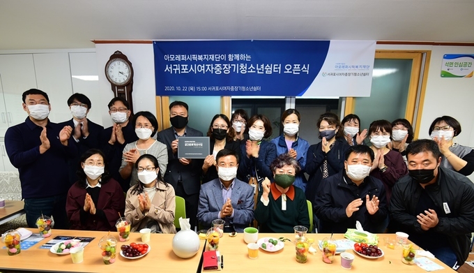 서귀포시 청소년쉼터 개소식에 참석한 아모레퍼시픽복지재단 김태우 부장(사진 뒷줄 왼쪽에서 다섯 번째), 서귀포시 여자중장기 청소년쉼터 강은숙 소장(여섯 번째)과 기관 임직원.