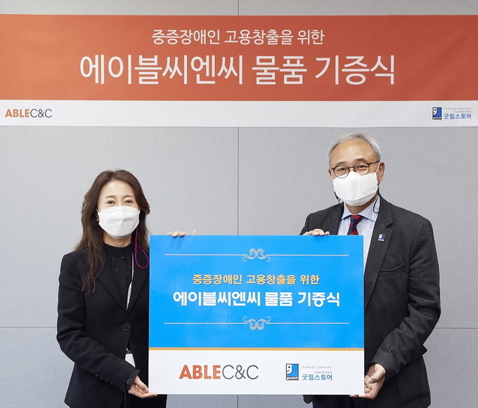 조정열 에이블씨엔씨 대표(좌)와 한상욱 밀알복지재단 굿윌스토어 본부장(우)이 물품 기증식 기념 촬영을 하고 있다.