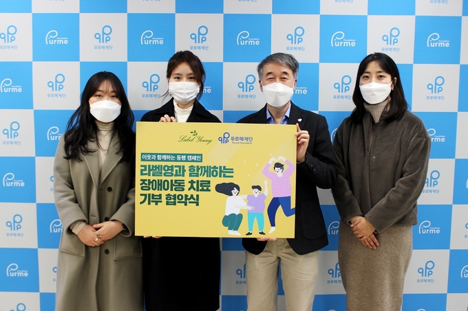 (왼쪽부터) 라벨영 마케팅팀과 백경학 푸르메재단’ 상임이사가 장애아동 치료 기부 협약식을 마치고 기념촬영을 하고 있다. 