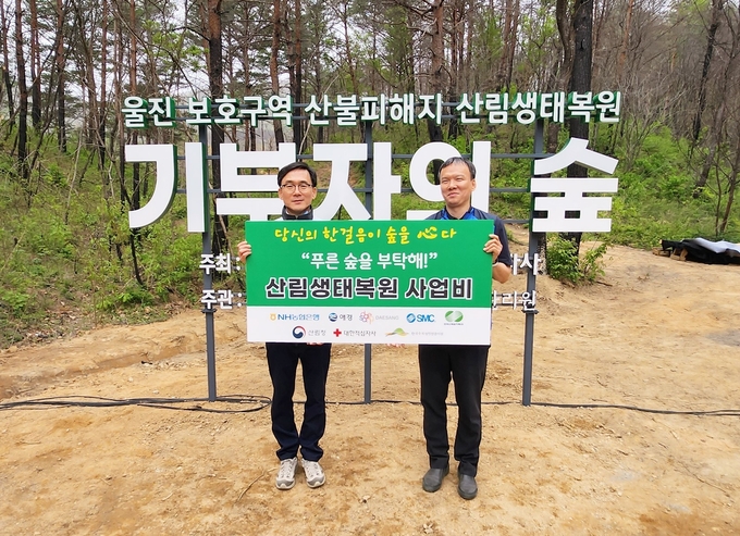 4월 21일 울진 산불 피해지역 나무심기 행사에 참여한 이상천 대한적십자사 사무총장(왼쪽)과 박찬영 애경산업 상무(오른쪽).