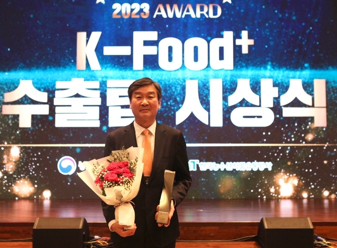 제 1회 K-푸드 플러스 수출탑 시상식에서 윤원일 대표가 최우수상을 수상하고 기념촬영을 위해 포즈를 취했다.