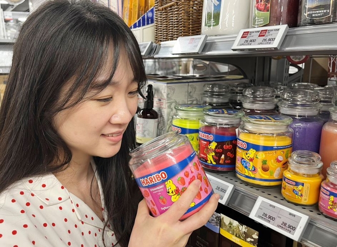 롯데마트 전국 96곳에 입점한 하리보 캔들이 소비자 접점 확대와 함께 할인 프로모션을 전개한다. 소비자가 하리보 캔들의 향을 맡고 있다.