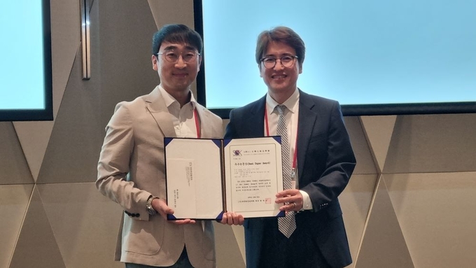 우수 논문상 수상자 송상훈 씨<사진 왼쪽>와 황재성 회장. 