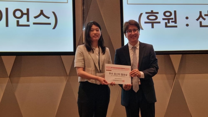 제형 부문 우수 포스터 발표상을 수상한 김성은 씨<사진 왼쪽>와 기념촬영을 하고 있는 황재성 회장. 
