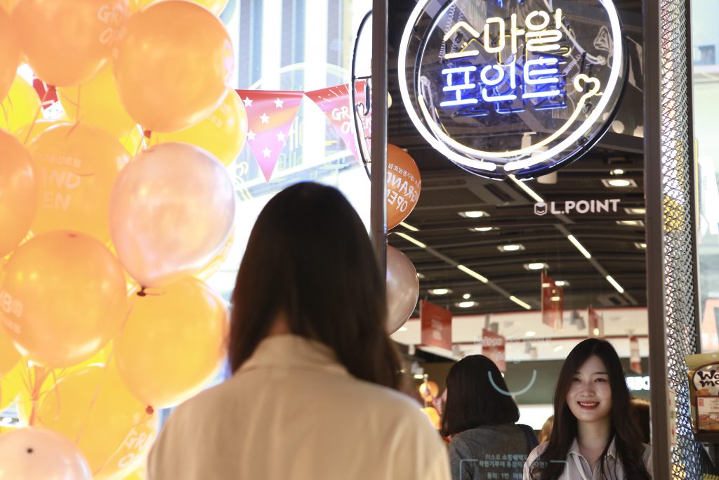 롭스에 방문한 고객이 매장에 설치된 매직 미러를 보고 미소를 짓고 있다.