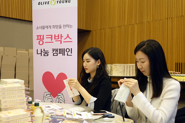 올리브영 임직원들이 '핑크박스 캠페인' 봉사활동 현장에서 직접 온열팩을 만들고 있는 모습