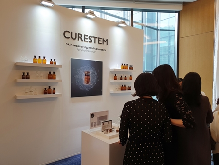 큐어스템은 의학적 전문성을 바탕으로 인체제대혈세포배양액의 효능효과를 극대화하고 병의원 피부재건 전문 메디 코스메틱 콘셉트에 맞춰 행사장 내에 특별한 쇼룸을 마련했다. 사진은 큐어스템 쇼룸에서 바이어들이 제품에 대한 설명을 듣고 있다.