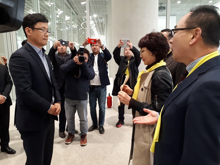 장명숙 회장<사진 오른쪽에서 두 번째 항의서한을 들고 있는 사람>이 심경은 이니스프리 영업상무<사진 왼쪽>에게 가맹점협의회의 주장과 요구를 담은 항의서한을 전달하고 있다. 사진 맨오른쪽은 전혁구 전국화장품가맹점연합회 공동회장.